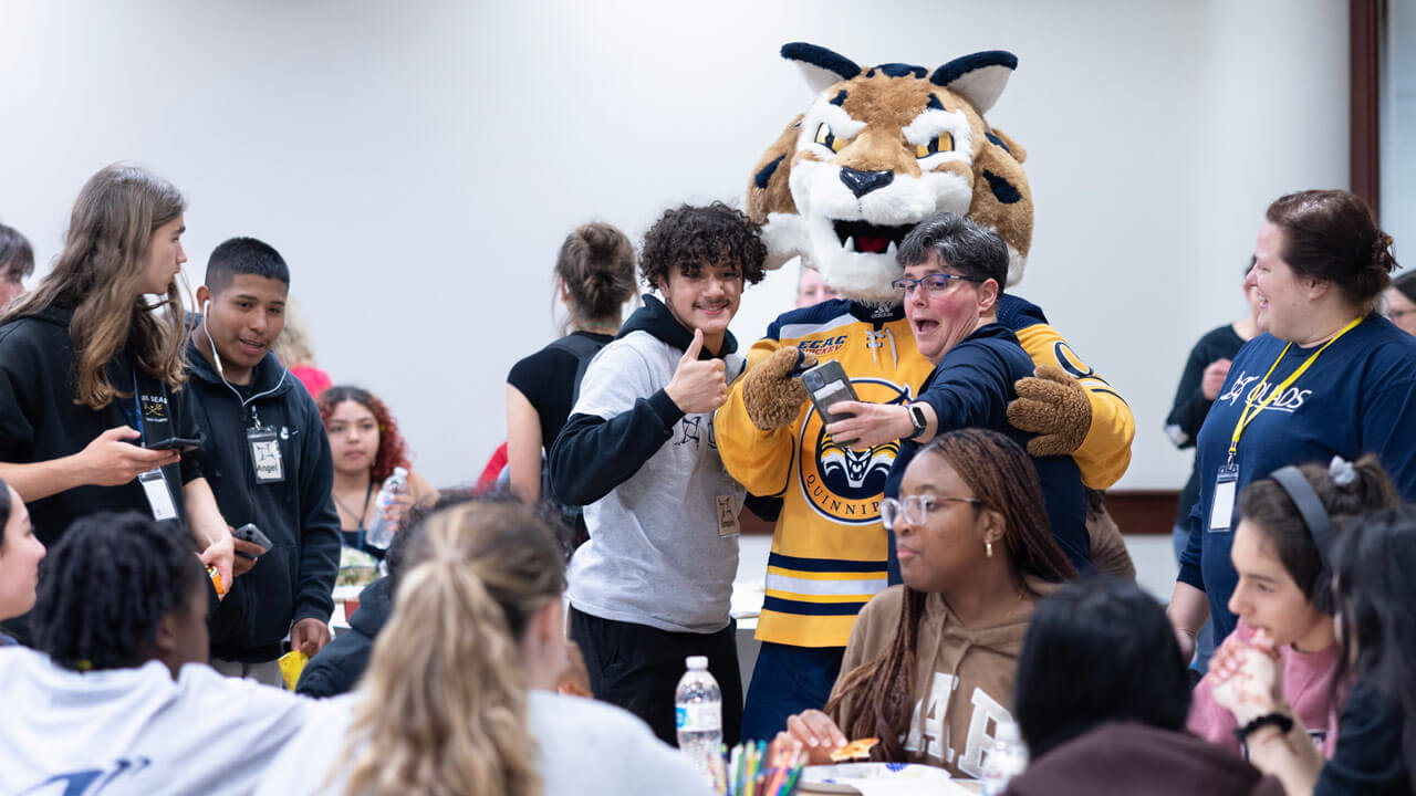 QUADS faculty and students pose with Boomer for a selfie.