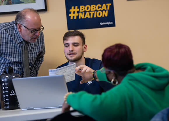 A finance student and professor assist a Hamden resident with her tax forms